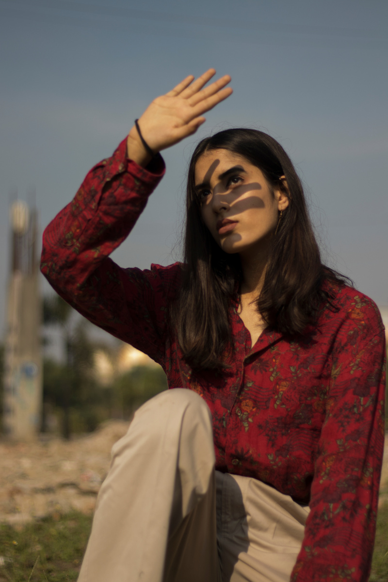 Woman in Maroon Dress Shirt Raising Her Hand